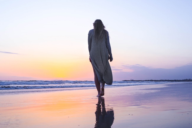 Eine Frau spaziert am Strand und folgt ihrer Intuition