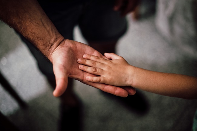 Vater reicht Kind die Hand