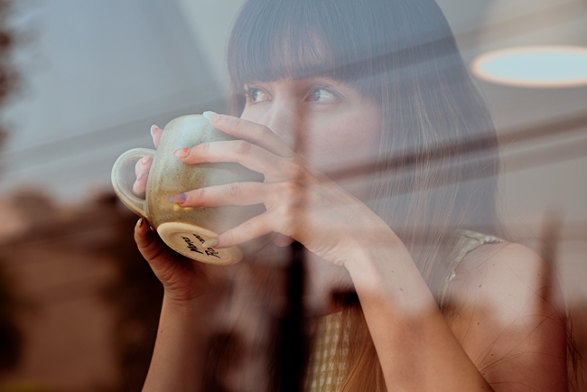 Eine Frau nippt energielos an ihrem Tee