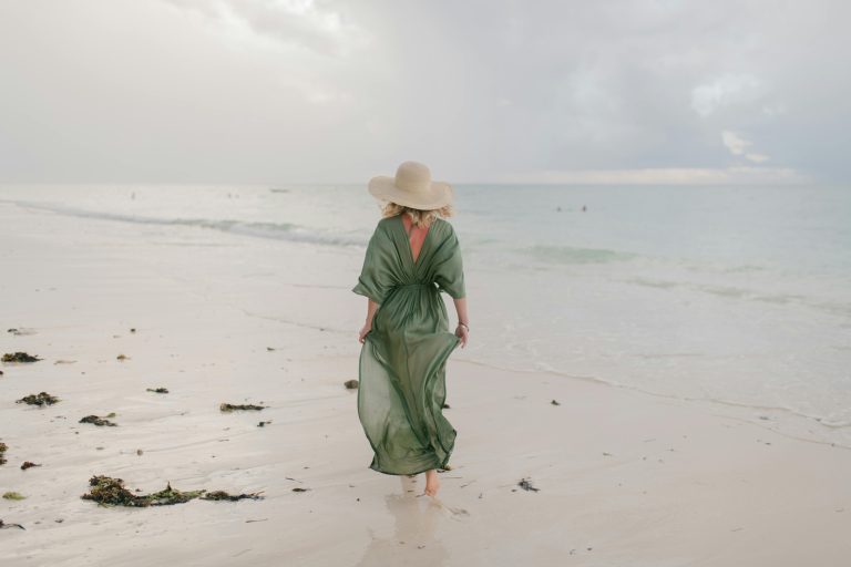 Frau am Strand, schaut aufs Meer
